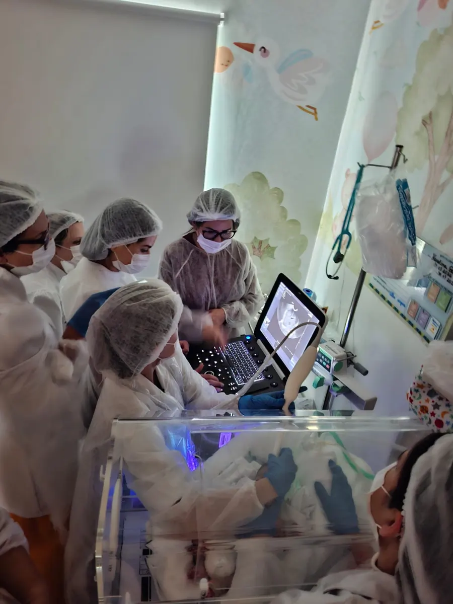 Alunas paramentadas acompanham o exame na UTI neonatal